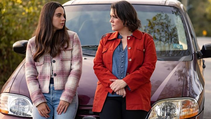 Callie and Shauna leaning against the car talking in a scene from Yellowjackets.