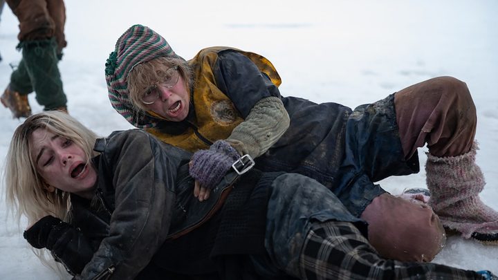 Misty holding Nat back on the ice in a scene from Yellowjackets.