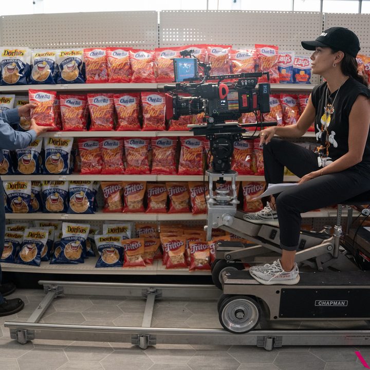 A man picks up cheetos while a director sits to his right in Flamin' Hot.