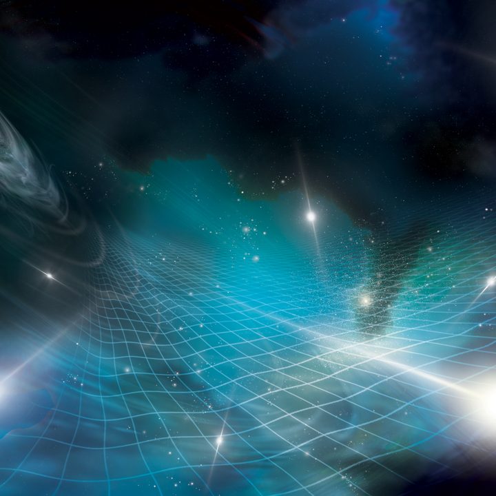 This artist’s concept shows stars, black holes, and nebula laid over a grid representing the fabric of space-time.