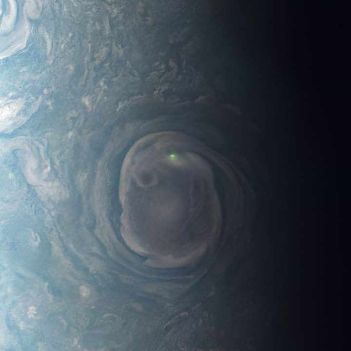 The glow from a bolt of lightning near a vortex near Jupiter’s north pole.