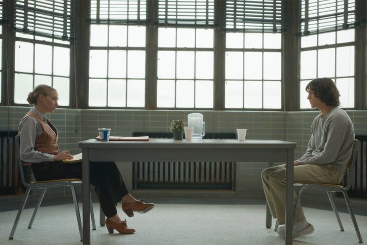 Amanda Seyfried and Tom Holland sit across a table from each other in The Crowded Room.