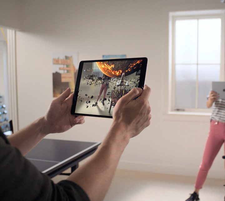Two people playing an augmented reality game on Apple iPad.