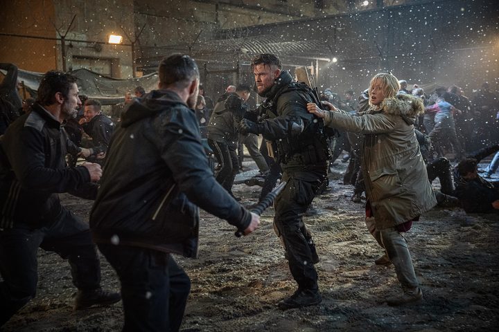 Chris Hemsworth protects a woman from two men in Extraction 2.