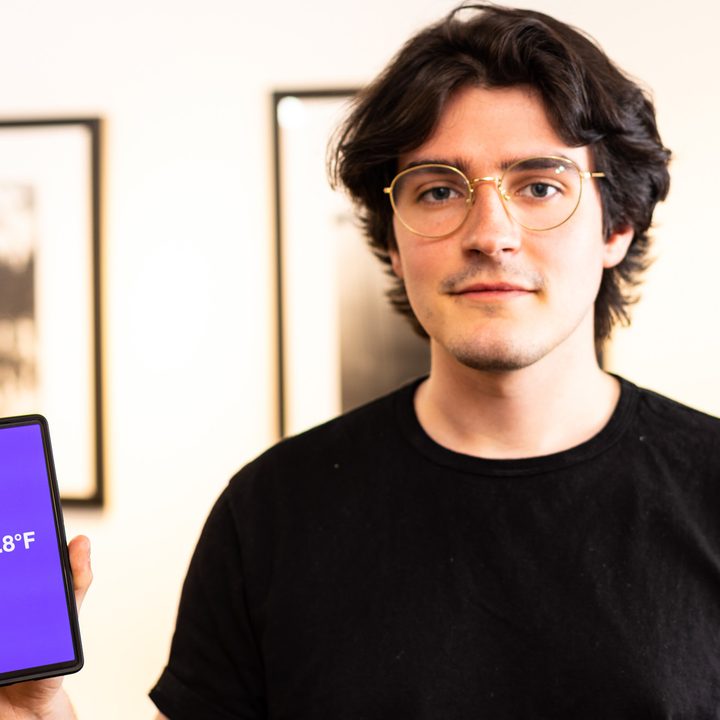 FeverPhone mobile app creator posing with the app on a phone.