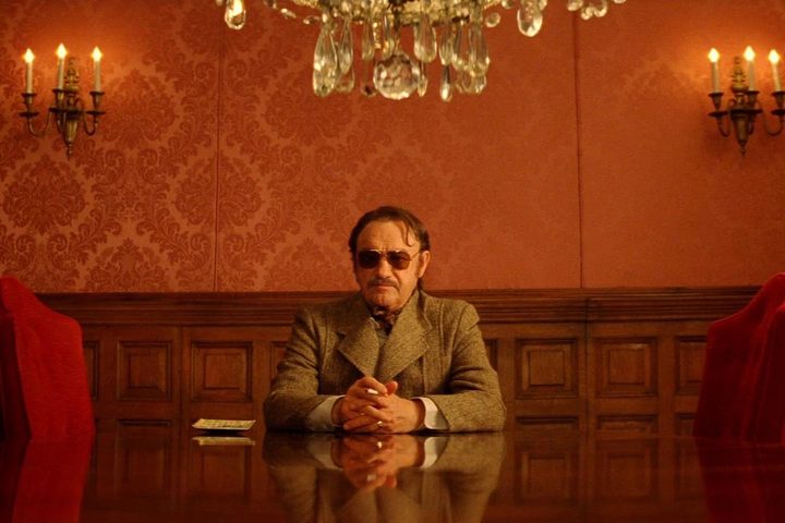 Gene Hackman sits at a table in The Royal Tenenbaums.