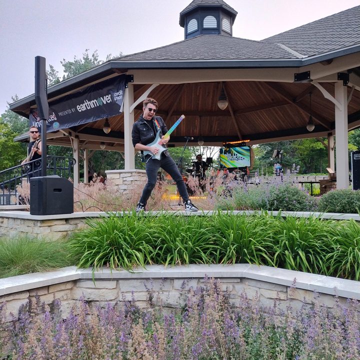 An image of a man playing an electric guitar underneath a gazebo taken using the Moto G 5G's main camera.