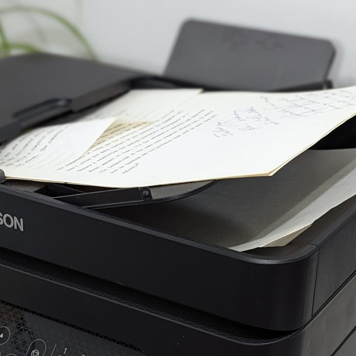 Paper emerges slightly wrinkled from a printer.