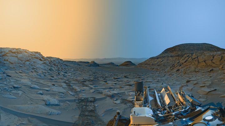 NASA’s Curiosity Mars rover used its black-and-white navigation cameras to capture panoramas of “Marker Band Valley” at two times of day on April 8. Color was added to a combination of both panoramas for an artistic interpretation of the scene.