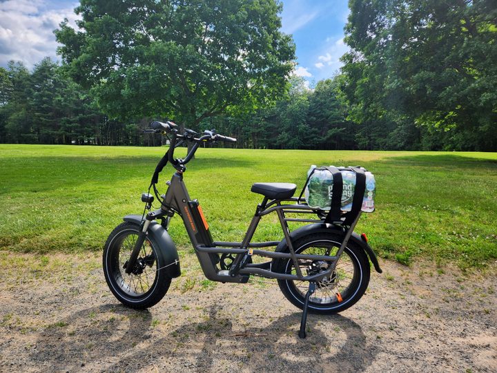 Rad Power Bikes RadRunner 3 Plus with a case of water bottles strapped to the rear rack.
