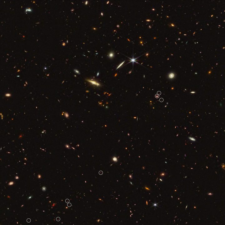 An arrangement of 10 distant galaxies marked by eight white circles in a diagonal, thread-like line.