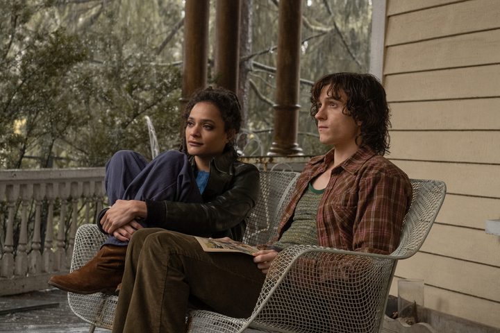 Sasha Lane and Tom Holland sit on a bench together in The Crowded Room.