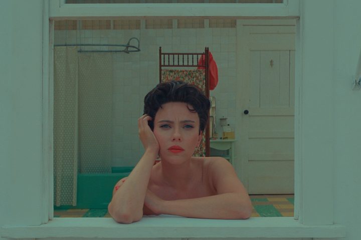 Scarlett Johansson leans on a window frame in Asteroid City.