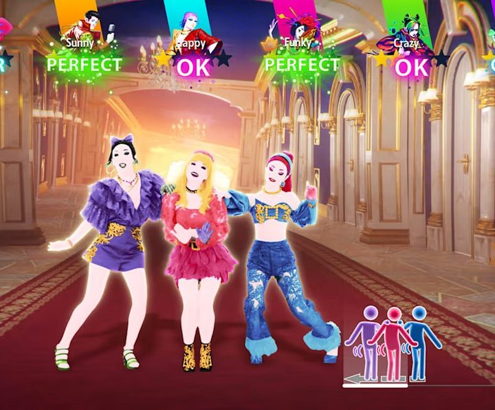 3 women in Just Dance 2023 stand close together at the center of the shot, performing a group dance move.