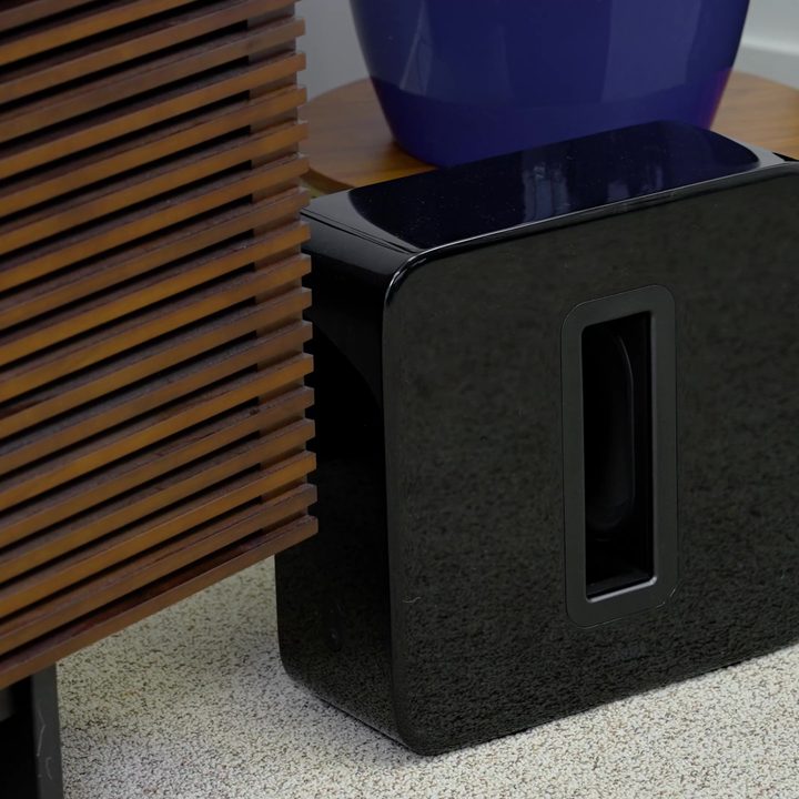 A Sonos Era 300 subwoofer by a media cabinet.