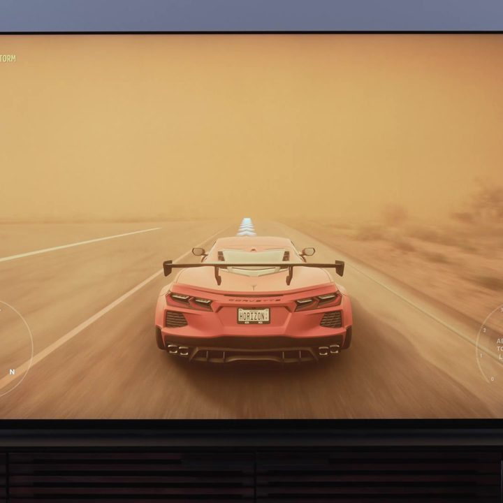 A red sports car on a dust-shrouded desert road on the Sony Bravia X93L mini-LED TV.