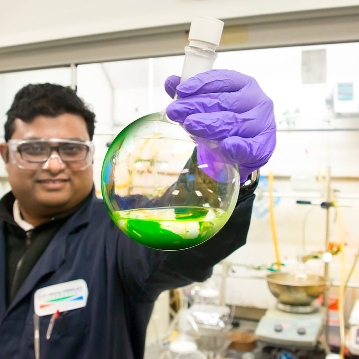 Universal Display Corporation chemist examining energy-efficient phosphorescent green OLED materials.