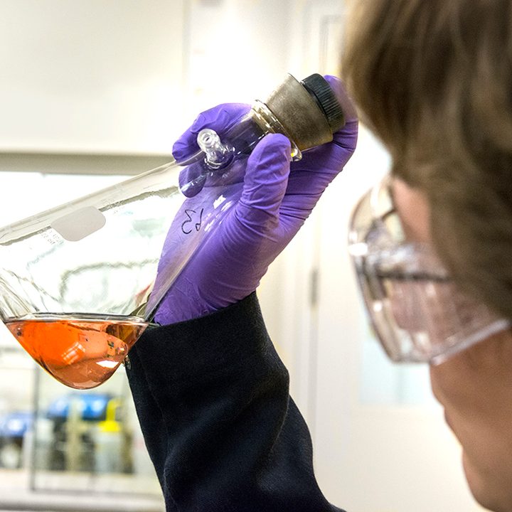 Universal Display Corporation chemist examining energy-efficient phosphorescent red OLED materials.