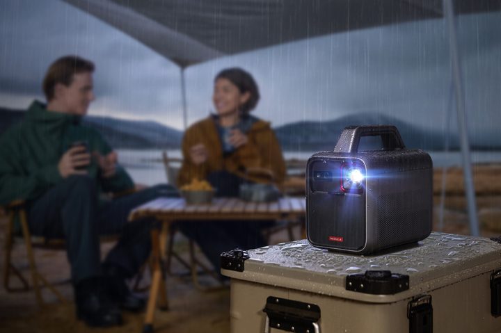 The Anker Nebula Mars 3 portable projector on a table under a tent.