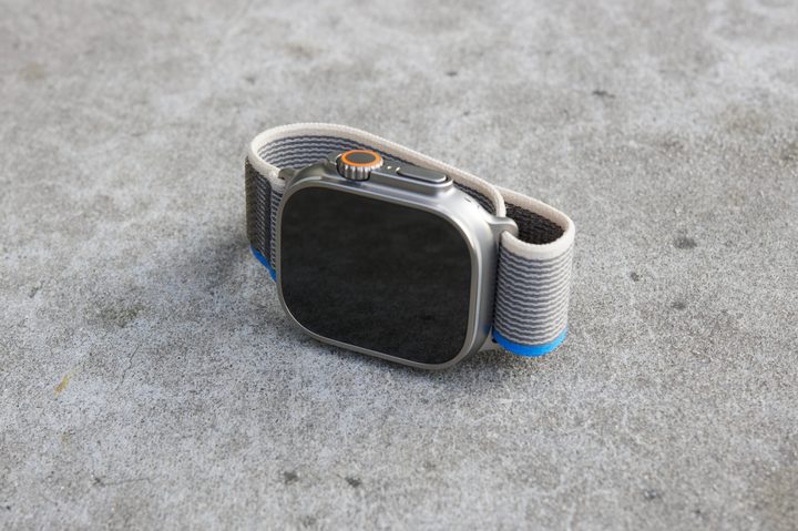 Apple Watch Ultra laying on its side on a concrete seat.