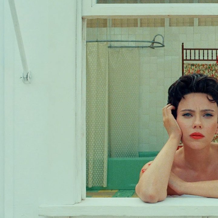 A woman looks out the window in Asteroid City.