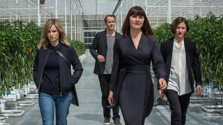 Four people walk through a greenhouse in a scene from the Hated in the Nation episode of Black Mirror.