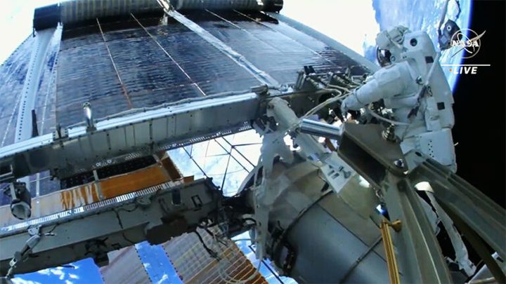 Astronaut Woody Hoburg watches as a new roll-out solar array deploys after he and fellow NASA spacewalker Stephen Bowen (out of frame) successfully installed it on the space station.