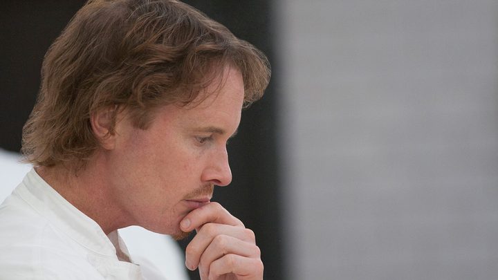 A side profile of Chef Grant Achatz staring into space in a scene from Chef's Table.