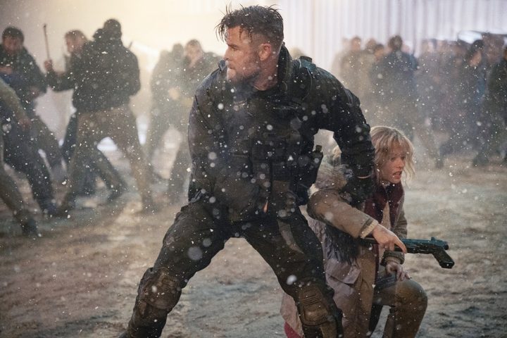 Tyler grips a child in battle in Extraction 2.