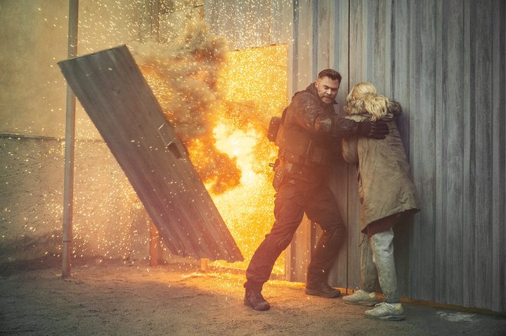 A man avoids an explosion in Extraction 2.