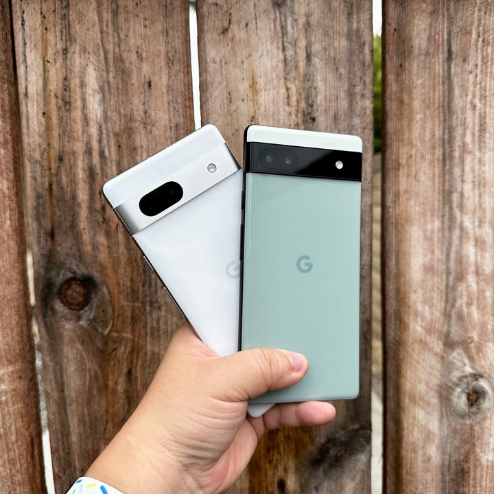 Sage green Pixel 6a and Snow Pixel 7a held in hand.