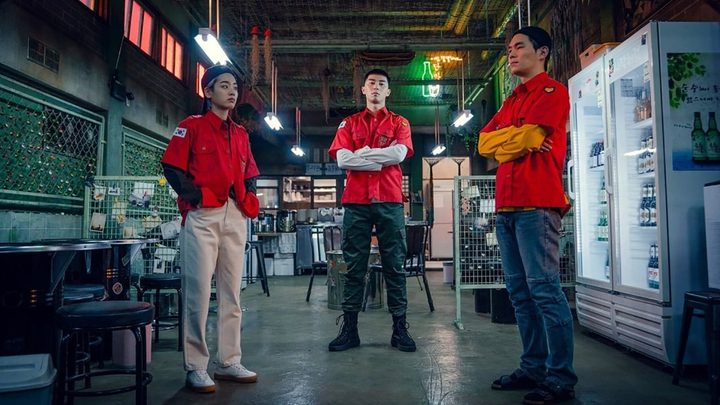 Three man stand in a warehouse looking place in a scene from Itaewon Class.
