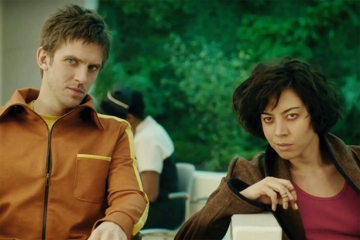 A man and a woman sit in Legion.