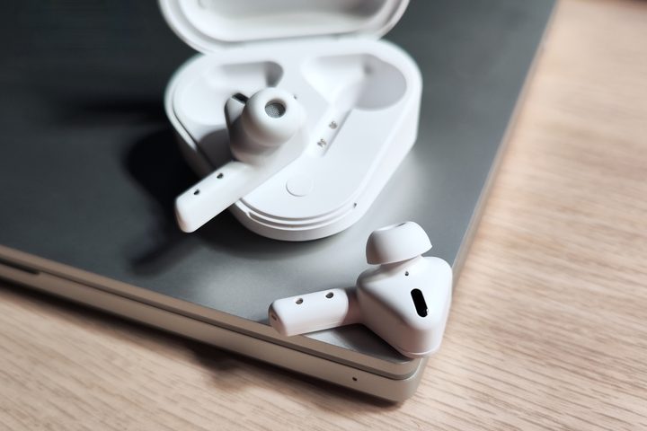 Monster DNA Go earbuds beside charging case.