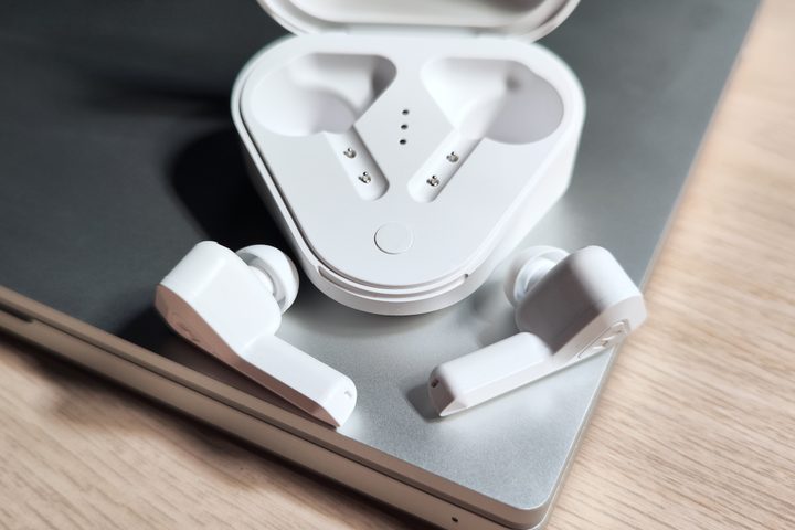Monster DNA Go earbuds beside charging case.