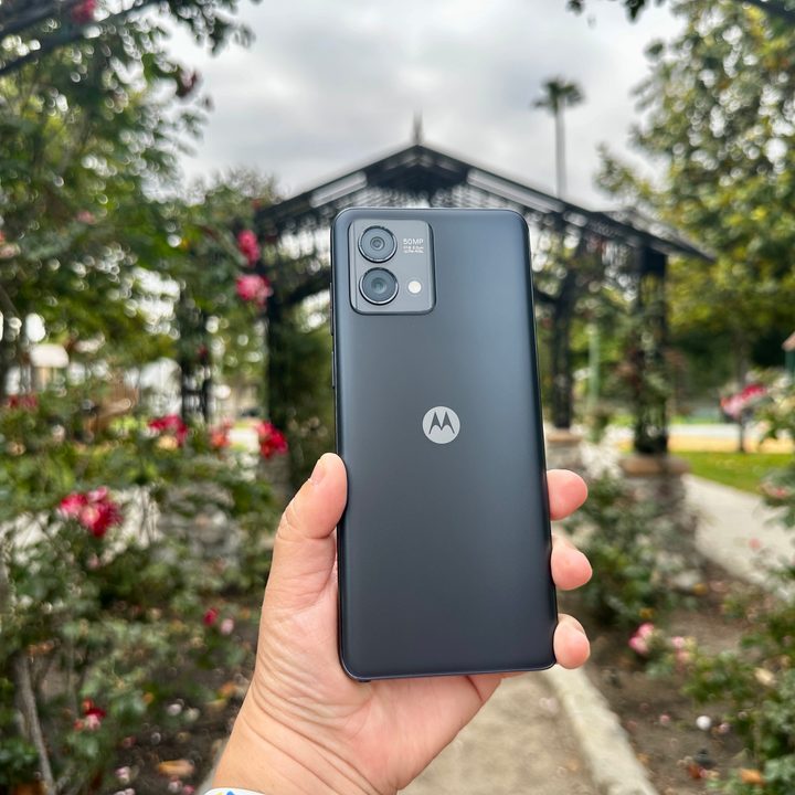 Moto G Stylus 5G 2023 in hand with a rose garden backdrop.