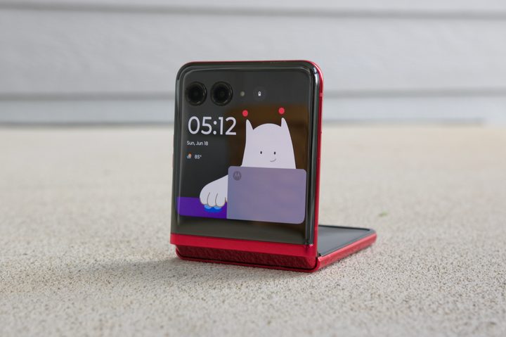 The Motorola Razr Plus, half-folded with a Lock Screen clock on the cover screen.