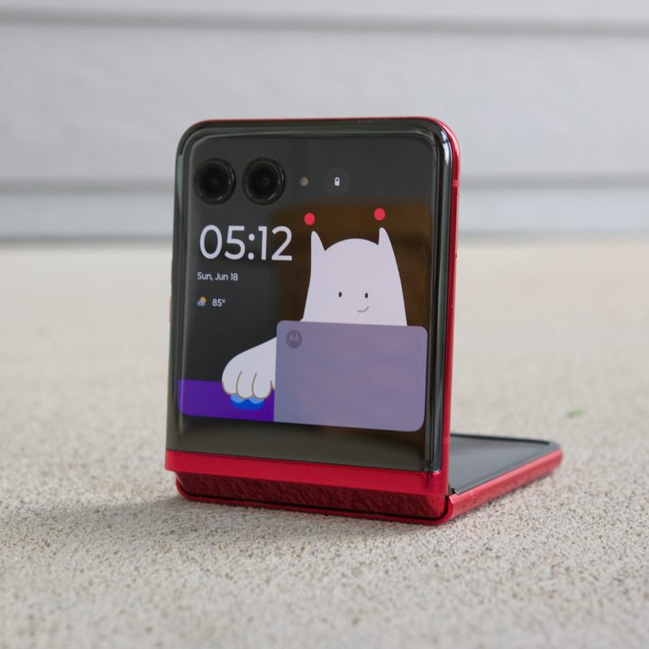 The Motorola Razr Plus, half-folded with a Lock Screen clock on the cover screen.