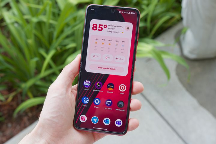 Someone holding the Motorola Razr Plus, fully open with the screen showing one of its home screens.