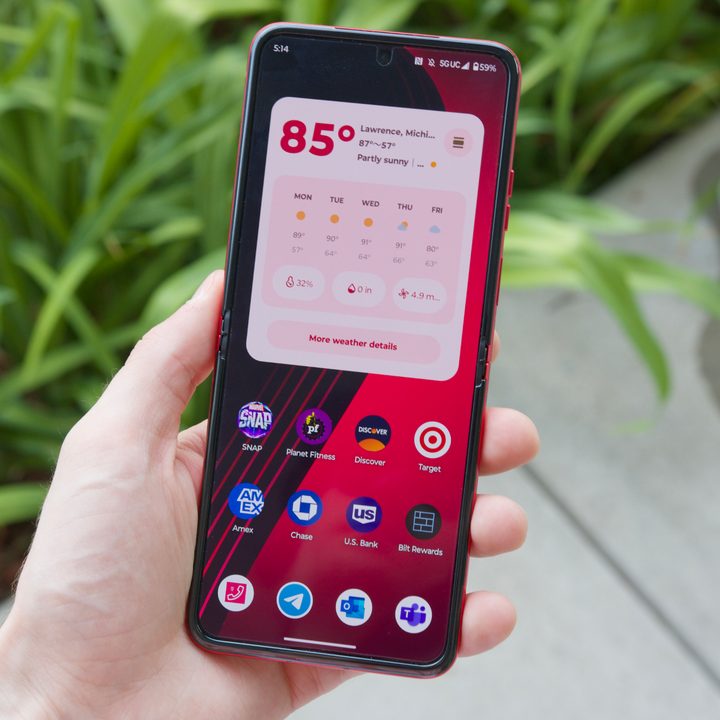 Someone holding the Motorola Razr Plus, fully open with the screen showing one of its home screens.