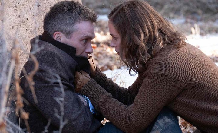 A woman grabs a man by the collar in Oppenheimer.