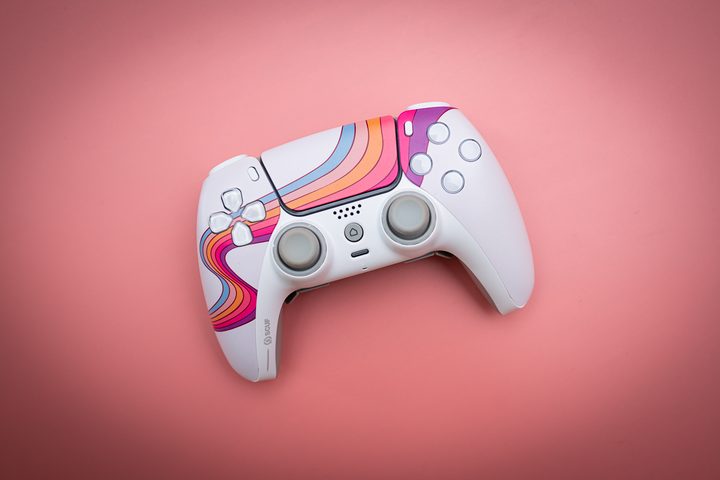 Scuf Reflex controller sitting on a pink background.