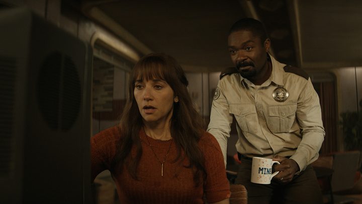 Allison on a computer, Holston standing behind her in a scene from Silo on Apple TV+.