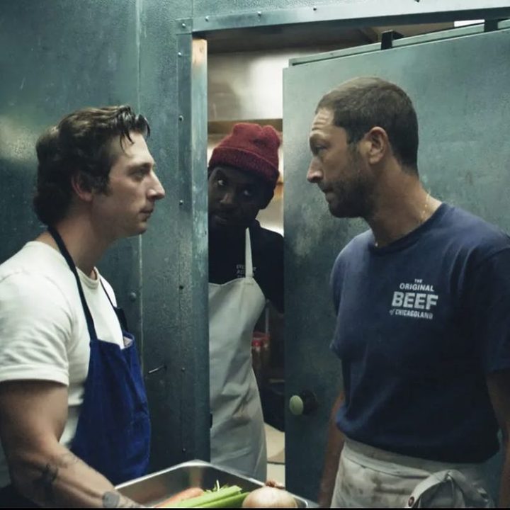 Two men stand in a walk-in freezer.