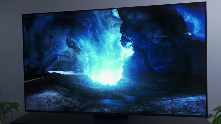 A bright phosphorescent glow in a cave shown on a TCL QM8.