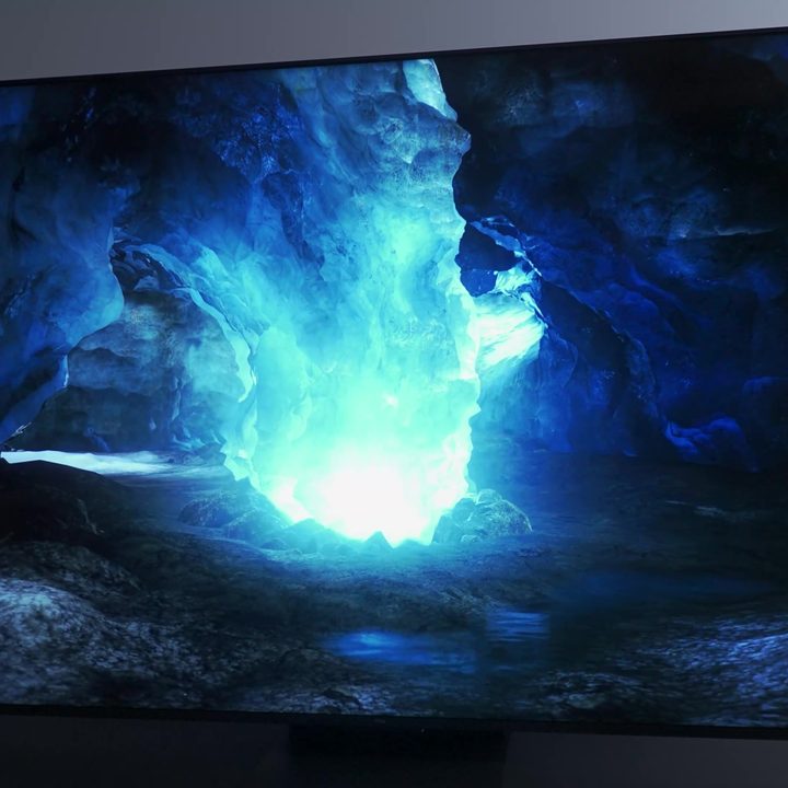 A bright phosphorescent glow in a cave shown on a TCL QM8.