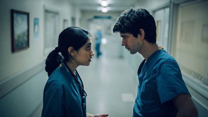 Two doctors look face to face in the hallway of a hospital in a scene from This Is Going To Hurt.