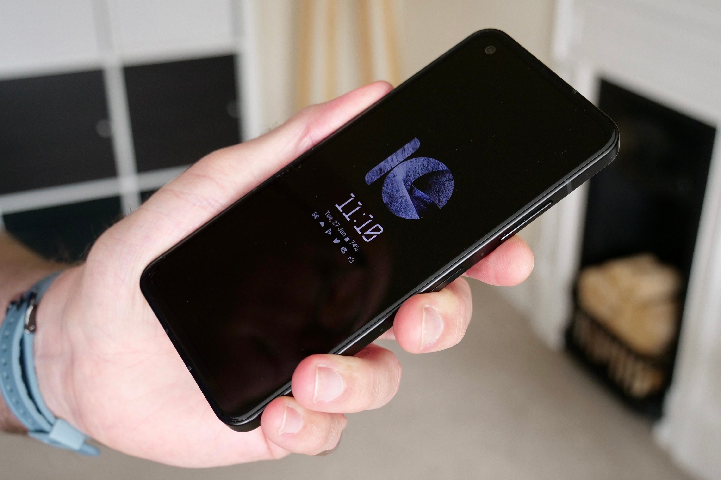 A person holding the Asus Zenfone 10 showing the always-on screen.