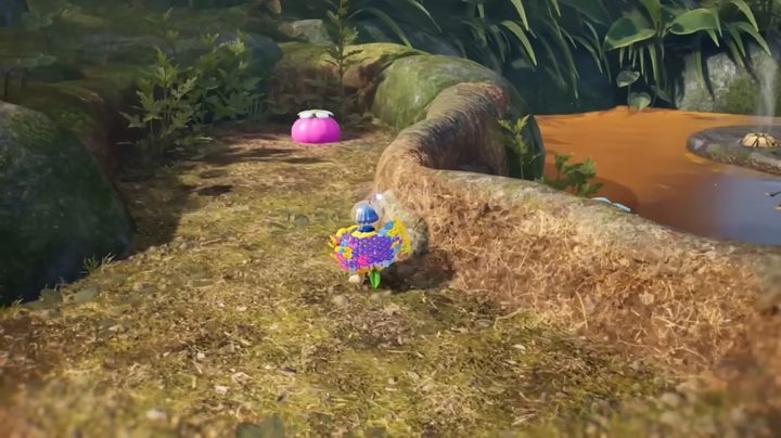 A spaceman with his pikmin near a pink onion.