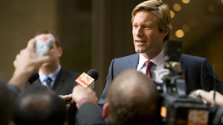 Aaron Eckhart as Harvey Dent giving an interview in The Dark Knight.